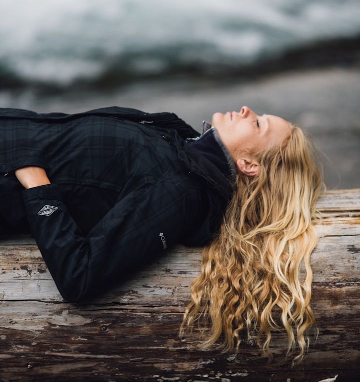 Frau legt Pause während einer Fastenwanderung auf einem Baumstamm ein. Deep Relax